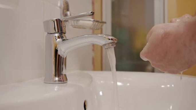 电晕病毒预防男子展示手卫生用热水肥皂洗手。使用肥皂。