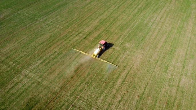 空中无人机射击商人农民使用拖拉机为农作物施肥液体化学品以获得更大的经济效益