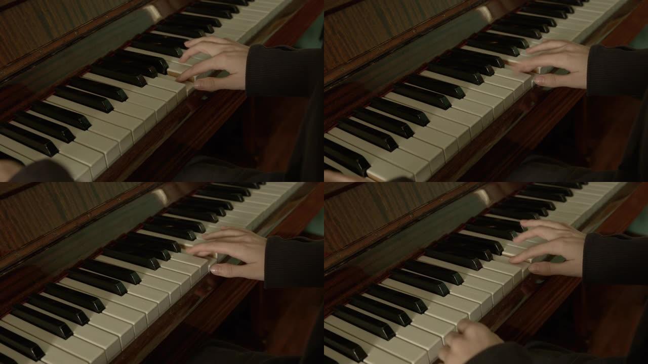 穿着深色衣服的优雅双手的年轻女子在老式钢琴上弹奏，自然采光