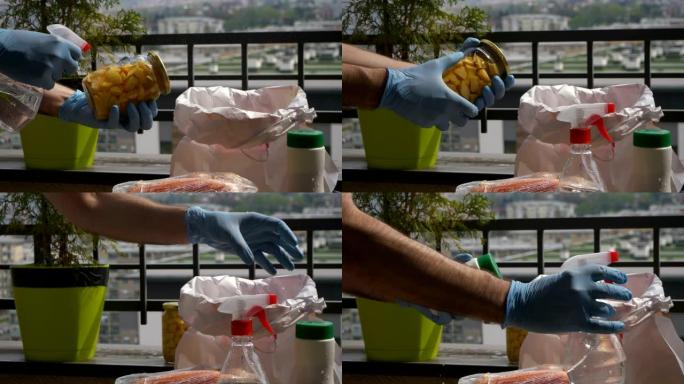 男子用消毒剂喷雾和防护橡胶手套清洗食品杂货