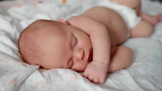可爱的2周大的新生婴儿正在床上睡觉。特写镜头。