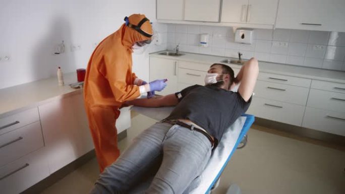 慢速Mo: 穿着危险品套装的护士从可疑新型冠状病毒肺炎患者零处采集血液样本-第3部分
