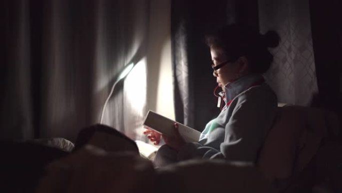 亚洲女子晚上在床上看书
