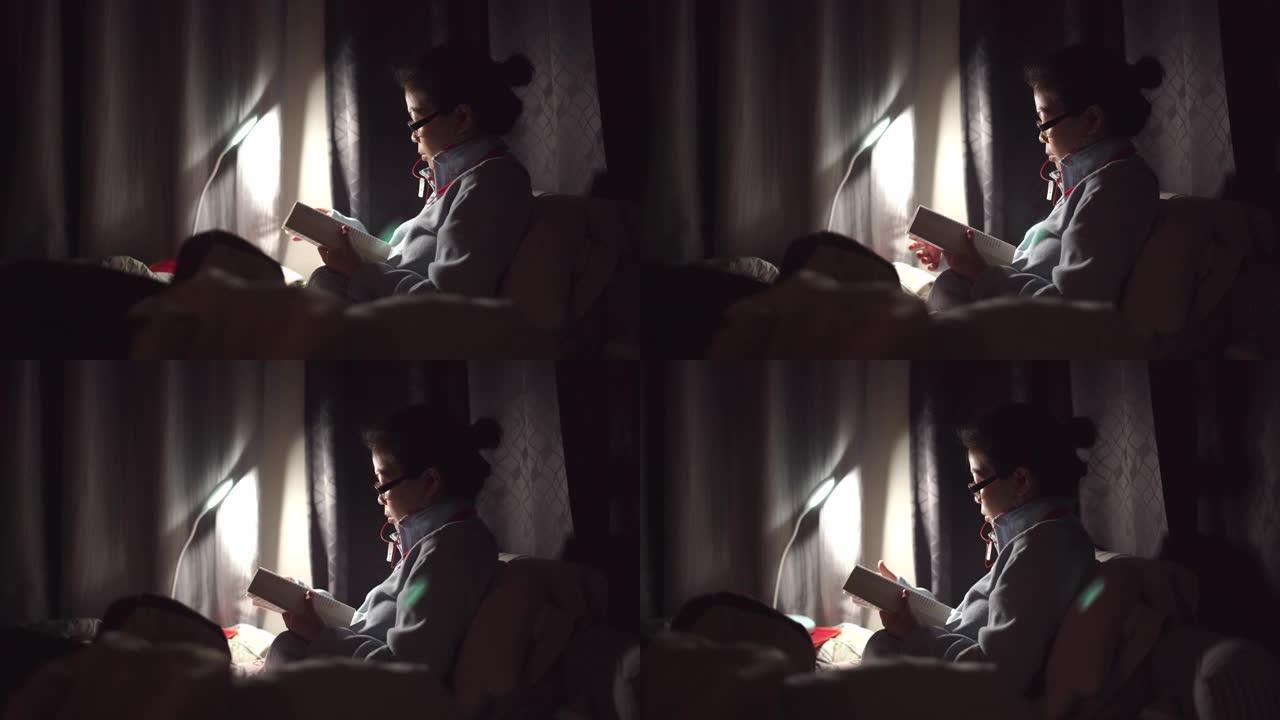 亚洲女子晚上在床上看书