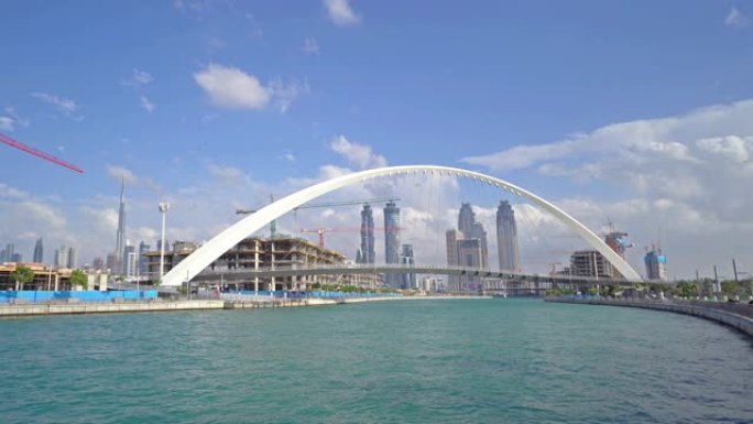 公差桥。湖泊或河流的建筑结构，迪拜市中心的天际线，阿拉伯联合酋长国或阿联酋。蓝天背景的城市金融区和商