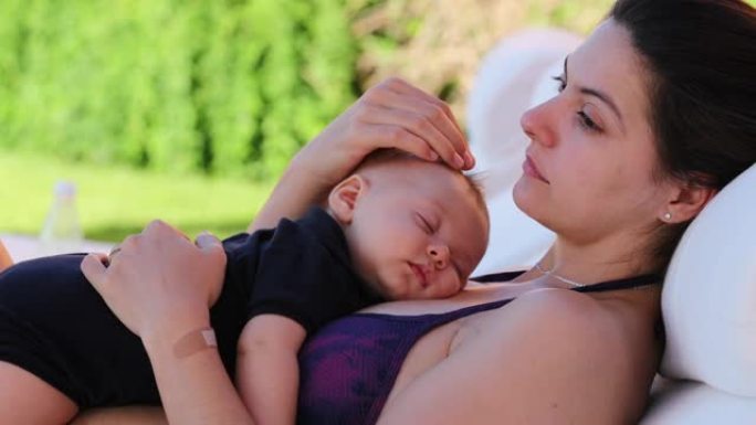 妈妈和婴儿一起在游泳池旁4个月大的婴儿与妈妈一起午睡