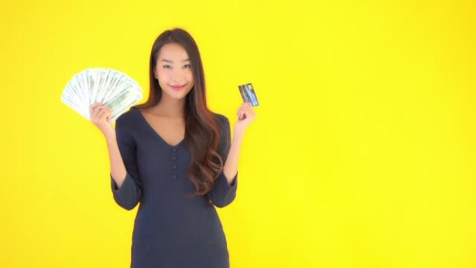 黄色背景上有大量现金和金钱的年轻亚洲女性