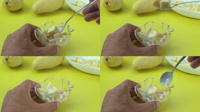 芒果掉入黄色桌子上的酸奶中