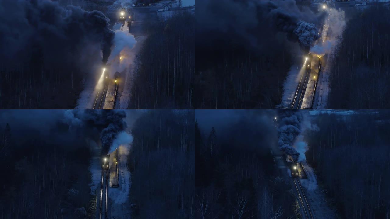 黑色蒸汽火车在夜间冬季森林中滚动的空中拍摄