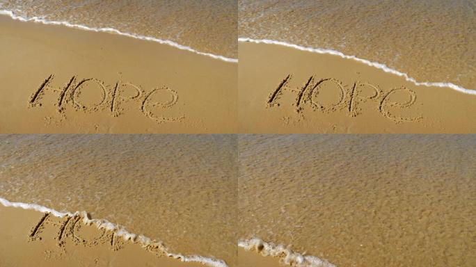 沙子上的铭文。海浪冲走了希望这个词。慢动作