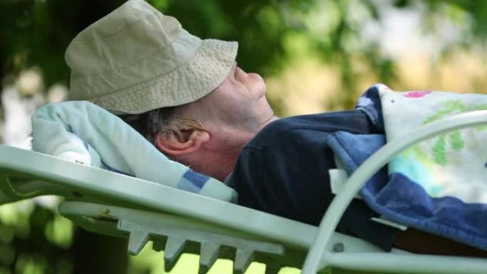 睡在树下的老人。高级退休男子在外面打盹
