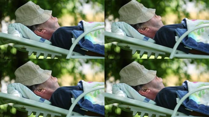 睡在树下的老人。高级退休男子在外面打盹