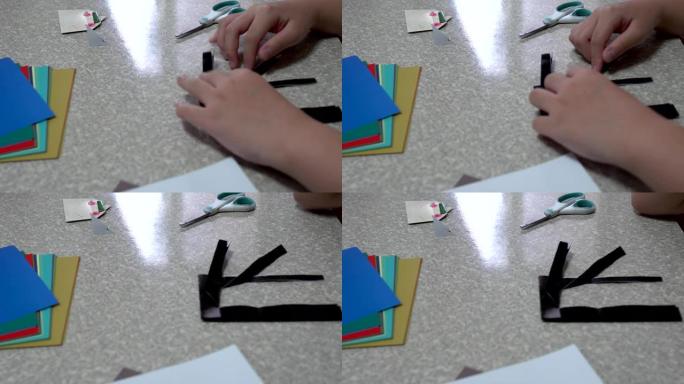 孩子正在家里做折纸。孩子正在家里做折纸。辅助工具是剪刀和胶水。主题在右边。