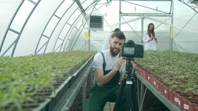 年轻的农民在温室里录像