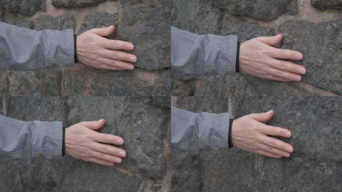 手放在石墙上。
