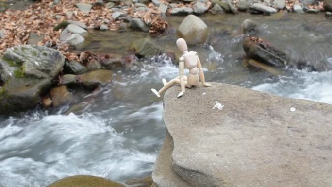 有关节的小矮人坐在石头上