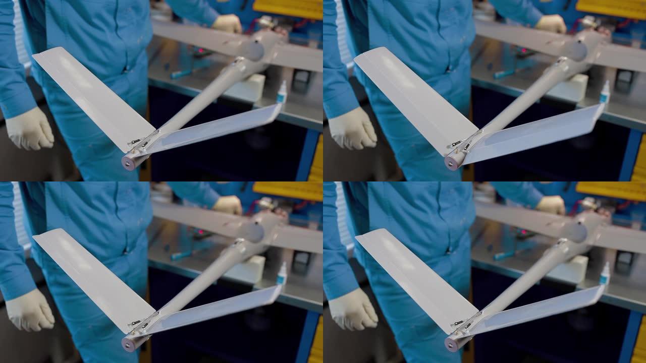 人员检查尾翼远程控制飞机的操作。生产无人机。工厂工程师在工厂准备商用空中监视或军用飞机。