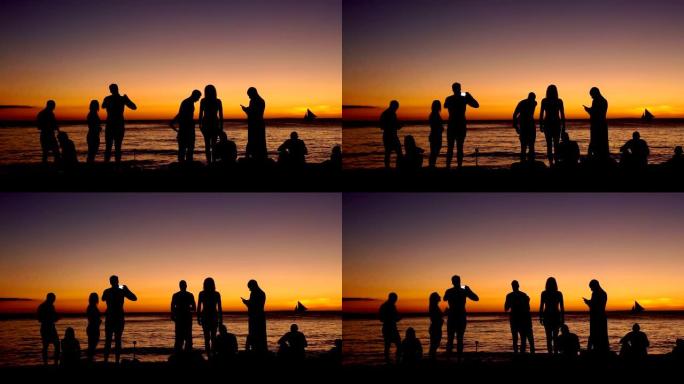 一群朋友在海滩上玩得开心的剪影
