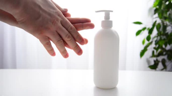 人的手在瓶子中使用凝胶，消毒剂，防腐剂