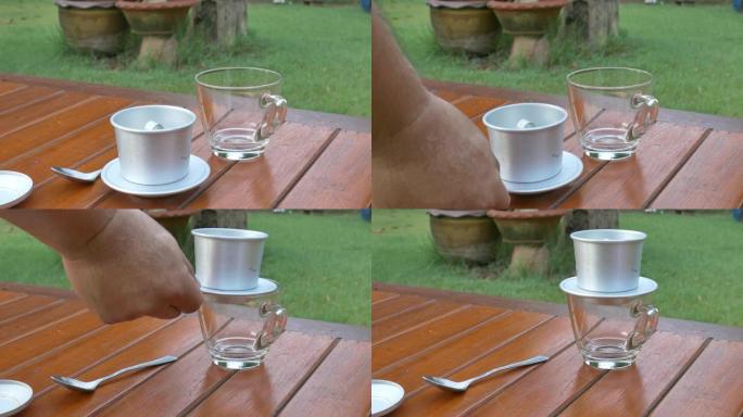 拿越南咖啡过滤杯放在咖啡杯上。