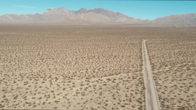 夏日，一条风滚草充满沙漠，中间有一条沙质道路