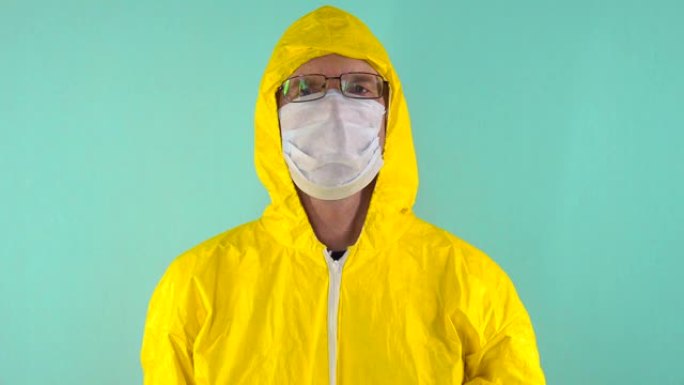 一名化学实验室工作人员穿着黄色防护服，戴着手套，戴着眼镜和口罩，在蓝色背景下看着框架。化学的概念