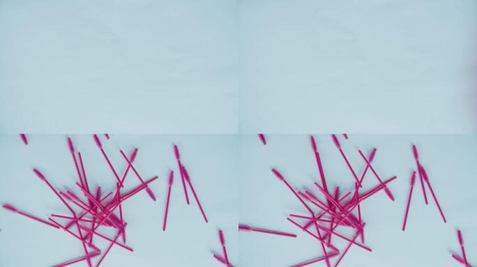 粉红色睫毛膏刷子宏观落在蓝色表面上