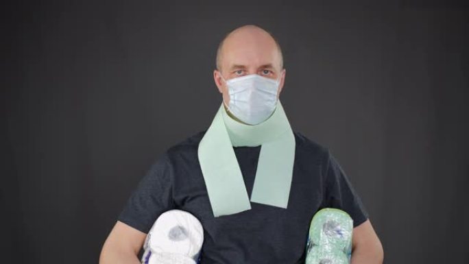 脸上戴着防护面具的成年男子肖像，腋下拿着卫生纸。大流行期间戴着医用口罩的男子。检疫有库存卫生纸的人。