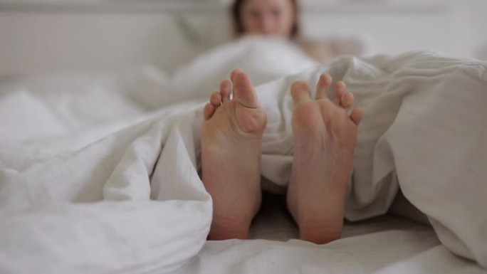 女性脚在白色床上移动