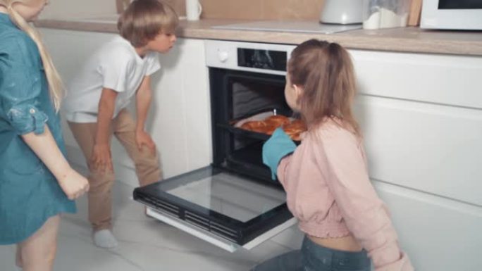 孩子们从烤箱里拿出新鲜的饼干。