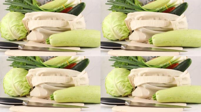 环保零废购物袋中的新鲜蔬菜和切菜板上的刀