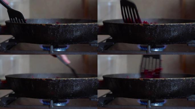 磨碎的甜菜在装有明火的煤气炉上，在油的煎锅中油炸。