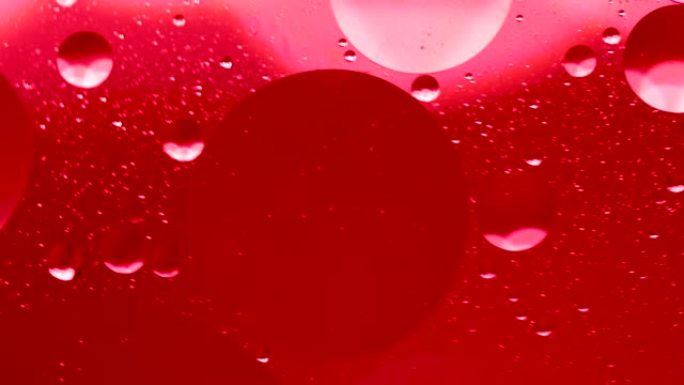 水面上的红色油滴抽象背景。气泡在液体中的运动，气泡宏观射击。特写镜头在水中。抽象手机主屏幕风格、主题