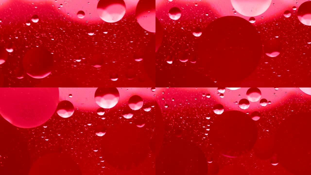 水面上的红色油滴抽象背景。气泡在液体中的运动，气泡宏观射击。特写镜头在水中。抽象手机主屏幕风格、主题