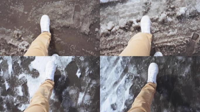 穿着白色运动鞋的男人走在潮湿的雪地泥泞的道路上春天POV视频