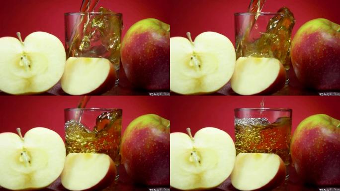 将苹果汁倒入红色背景上成熟的苹果旁边的玻璃杯中