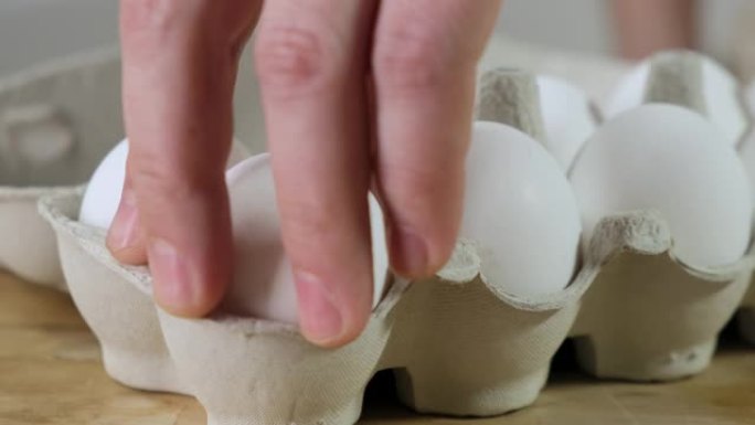 用手从纸箱包装的鸡蛋中取一个。