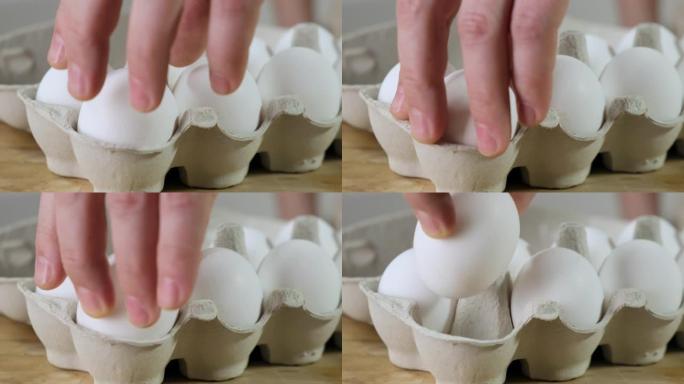用手从纸箱包装的鸡蛋中取一个。