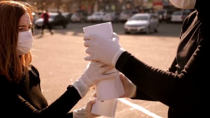 戴着医用口罩的夫妇在停车场用卫生纸玩得开心。新型冠状病毒肺炎。