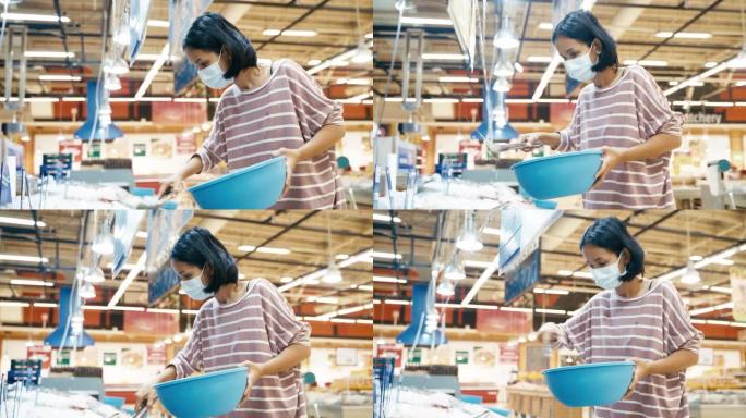 年轻的亚洲妇女选择虾和海鲜冷冻在超市商店的冰与面罩保护从电晕病毒或COVID19和流感健康。