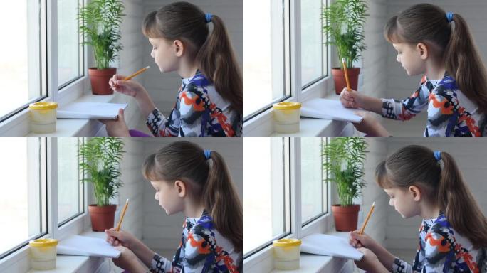 女孩在相册里用铅笔在窗户旁画画