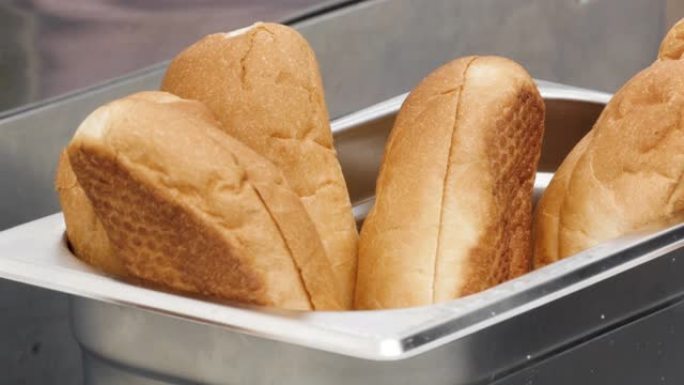 关闭金属金属容器内新鲜出炉的面包。库存镜头。美味的软面包制作三明治，面粉产品概念。