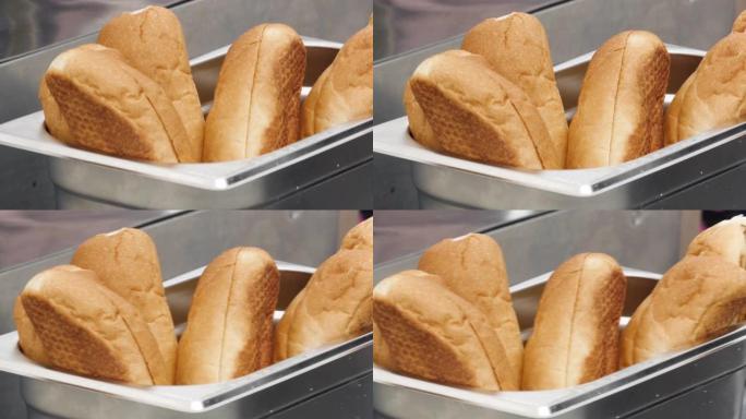关闭金属金属容器内新鲜出炉的面包。库存镜头。美味的软面包制作三明治，面粉产品概念。