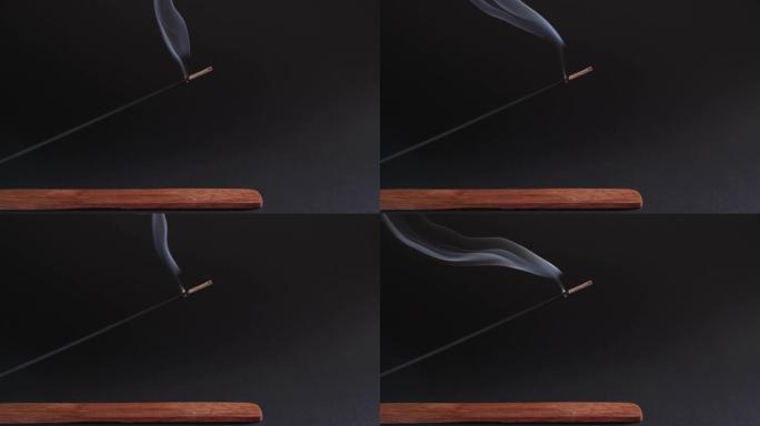 熏香在一个美丽的木架上燃烧，背景是黑色的。芳香疗法促进健康和繁荣。禅定、禅与自知的概念4k