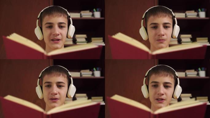 年轻的学生在木制书柜的背景下大声朗读一本书