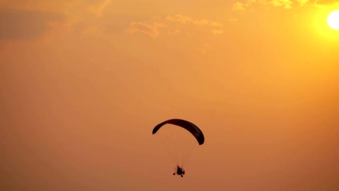 日落天空背景上的剪影滑翔伞