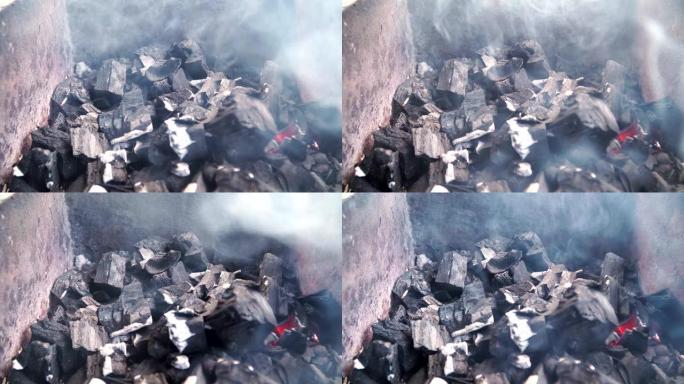 烧烤炉中燃烧的煤的特写镜头。煤开始燃烧。烹饪篝火食物