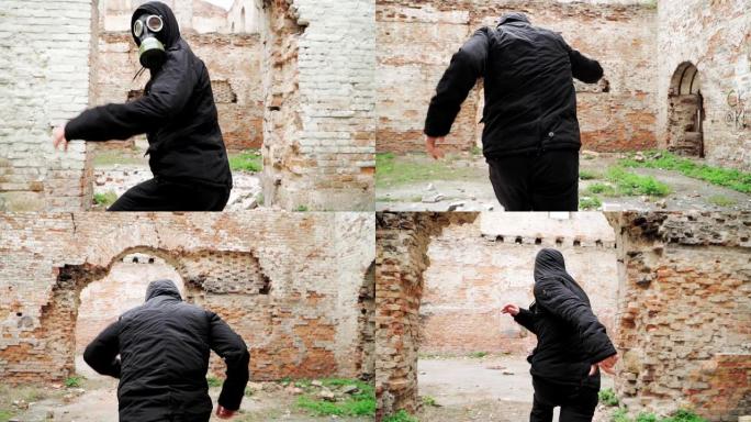 戴着防毒面具和黑色衣服的男子在一座废弃的废墟建筑上奔跑。跟踪者概念，核化学战争后的幸存者。慢动作。