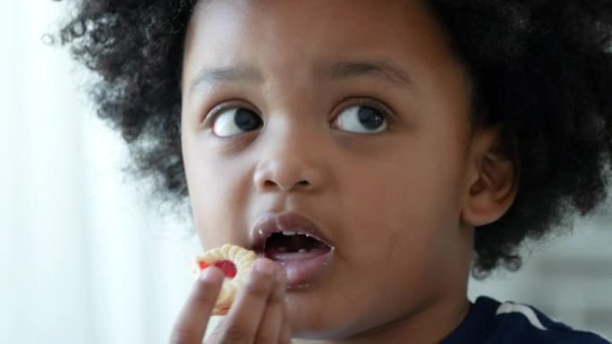 非裔美国人小男孩在吃饼干时牙痛