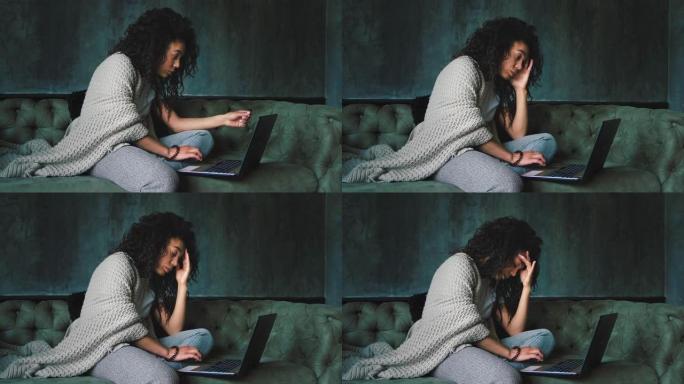 年轻的非洲裔美国妇女对在家中使用笔记本电脑阅读新闻感到失望。黑暗的电影外观